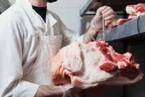 Cropped image of Butcher hanging cow head — Stock Photo