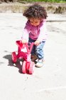 Девушка играет с трехколесным велосипедом в парке — стоковое фото