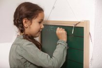 Дівчина писати на маленьку дошці — стокове фото