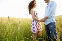 Couple holding hands in a wheat field — Stock Photo