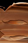 Fond de teint cosmétique barbouillé, ton brun foncé — Photo de stock