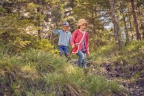 Dos niños pequeños explorando el bosque - foto de stock