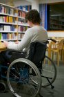 Disabile lettura uomo in biblioteca — Foto stock
