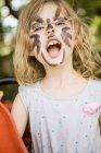 Retrato de menina vestindo rosto pintura facial exprecing ao ar livre — Fotografia de Stock