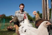 Mann füttert Hühner im Freien — Stockfoto