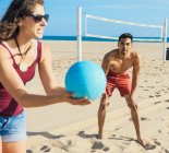 Gruppo di amici che giocano a pallavolo sulla spiaggia — Foto stock