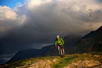 Гірський велосипедист на трав'яному схилі пагорба — стокове фото