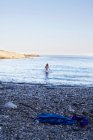 Girl wading into the ocean — Stock Photo