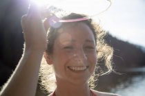 Mujer joven sonriendo a la luz del sol - foto de stock