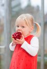 Toddler girl eating fruit cake — Stock Photo