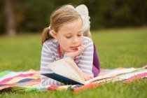 Menina leitura livro no piquenique cobertor — Fotografia de Stock