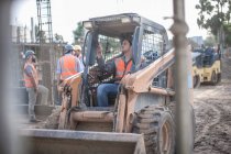 Bauarbeiter fährt Bagger auf Baustelle — Stockfoto