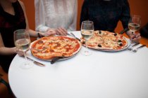 Young women eating pizza in restaurant — Stock Photo