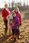 Retrato de madre e hijas de pie con pony - foto de stock