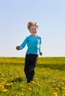 Junge rennt in Blumenfeld — Stockfoto