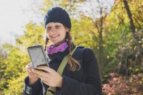 Молода жінка в сільському середовищі за допомогою смартфона — стокове фото