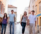 Couples walking on cobbled street — Stock Photo