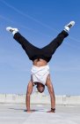 Man doing handstand on urban rooftop — Stock Photo
