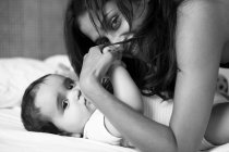Mother and baby laying on bed — Stock Photo