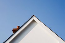 Низький кут зору білизни будинку на тлі прозорого блакитного неба в сонячний день — стокове фото