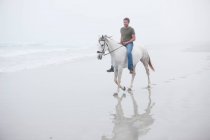 Homem montando cavalo na praia — Fotografia de Stock