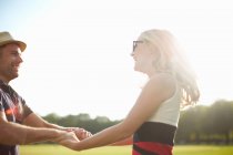 Couple swirling each other around in park — Stock Photo