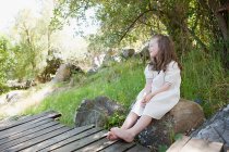 Menina sentada na rocha — Fotografia de Stock