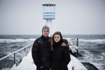 Paar umarmt sich auf schneebedecktem Steg — Stockfoto
