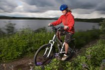 Woman mountain biking on dirt path — Stock Photo