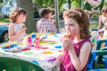 Young girl eating ice cream at kindergarten party — Stock Photo