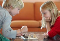 Діти грають у шахи у вітальні — стокове фото