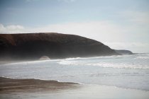Waves crashing on sandy beach — Stock Photo