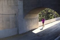 Jogger running on bridge, Arroyo Seco Park, Pasadena, California, USA — Stock Photo