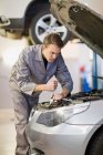 Mechaniker arbeitet in Garage an Auto-Motor — Stockfoto