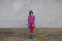 Молода жінка стоїть з укулелею на стіні — стокове фото