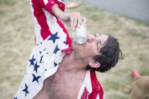 Jovem beijando lata de cerveja celebrando o Dia da Independência, EUA — Fotografia de Stock