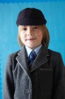 Junge in Schuluniform lächelt mit einem zahmen Grinsen in die Kamera — Stockfoto
