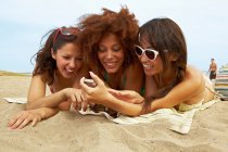 Mujeres jóvenes tomando el sol en la playa - foto de stock