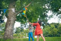 Enfants se balançant à pinata à la fête — Photo de stock