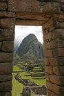 Machu Picchu through stone wall — Stock Photo