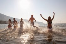 Giovani amici schizzi in mare — Foto stock