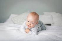 Baby boy crawling on bed — Stock Photo