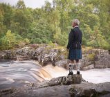 Человек, смотрящий на реку в традиционном шотландском костюме Принца Чарли с Дугласом Современным Тартаном — стоковое фото