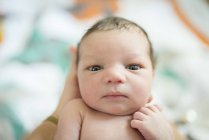 Retrato del bebé recién nacido mirando a la cámara - foto de stock