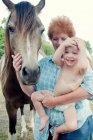 Бабушка и ребенок с пони — стоковое фото