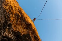 Скелястий альпініст масштабує круте скелясте обличчя — стокове фото