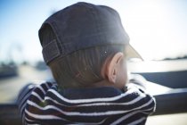 Rückansicht Junge mit Mütze lehnt an Geländer — Stockfoto