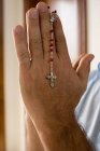 Uomo in possesso di un rosario — Foto stock
