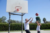 Hombre y nieto jugando baloncesto - foto de stock