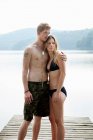 Couple debout sur la jetée sur le lac — Photo de stock